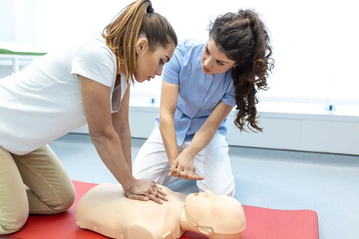 Pflegekraft übt Herzdruckmassage an einer Reanimationspuppe beim Notfalltraining